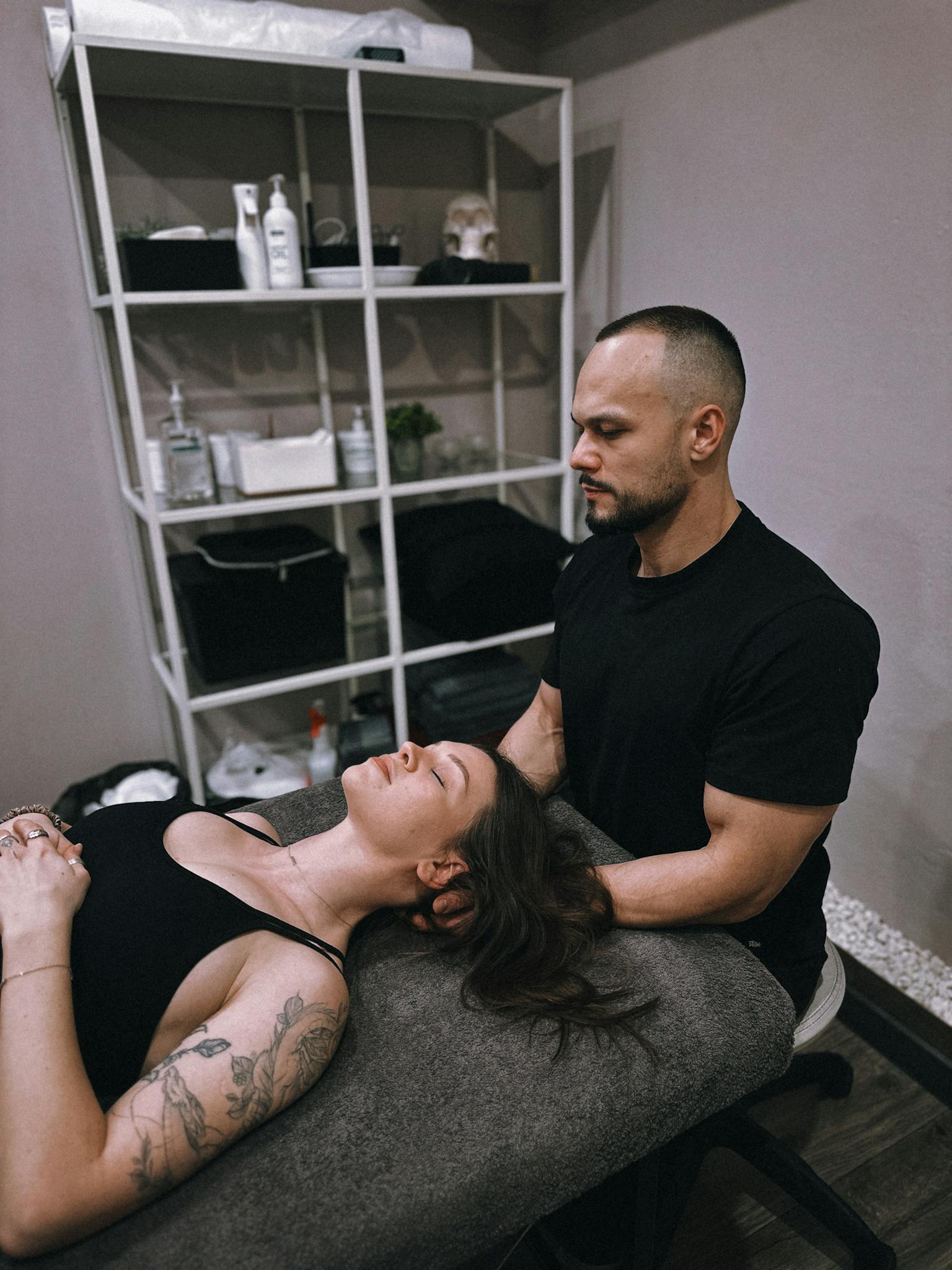A chiropractor provides therapy to a relaxed patient in a calming, indoor setting.